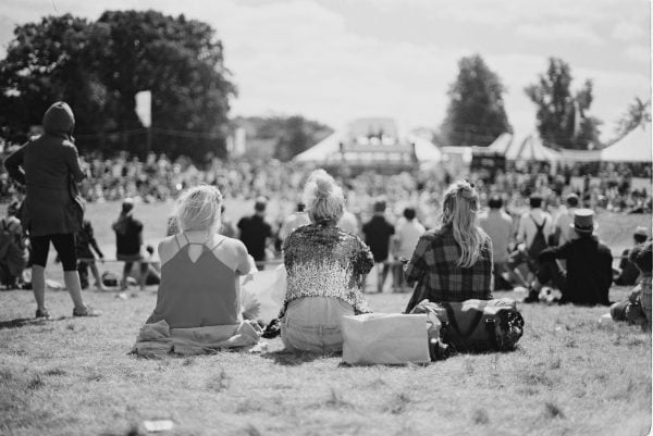 Festival goers sit at festival in black and white image